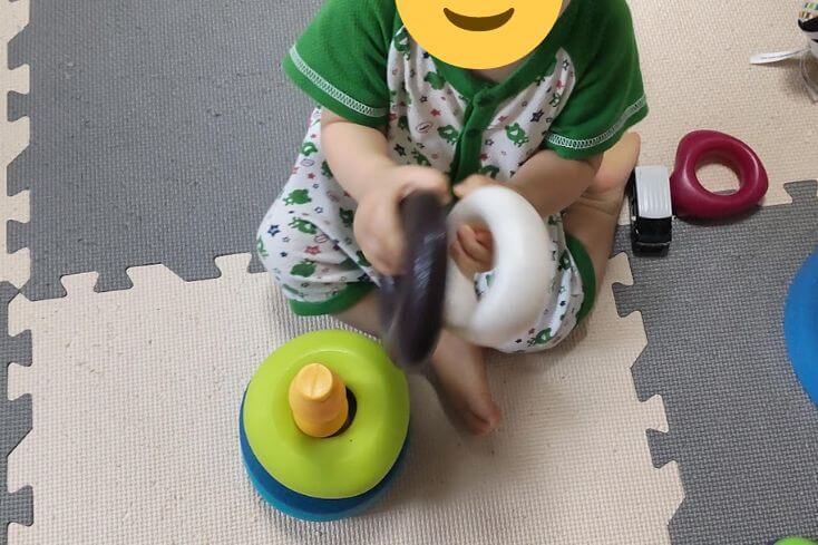 トイサブから届いたおもちゃの｢Skipping Stones｣のリングをカンカンぶつけて遊んでいるところの写真
