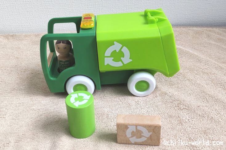AndTOYBOX(アンドトイボックス)から届いた4つめのおもちゃ｢ライト＆サウンド付きゴミ収集車｣のゴミ収集車と付属品の人形と円柱のおもちゃと長方形のおもちゃの写真