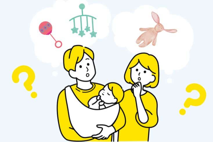 新生児を抱っこしている夫婦がおもちゃについて考えているイラスト
