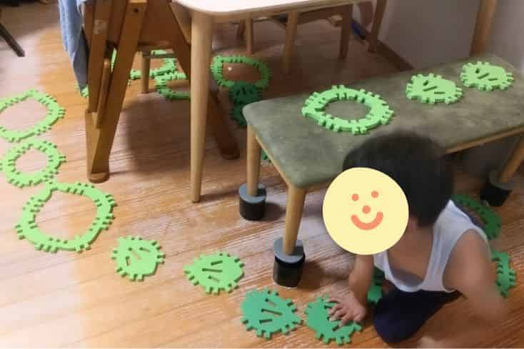 クムタスをテーブルの下やイスの上にバラバラに置き、その上を通る遊びを息子(小1)が考えて遊んでいるところの写真