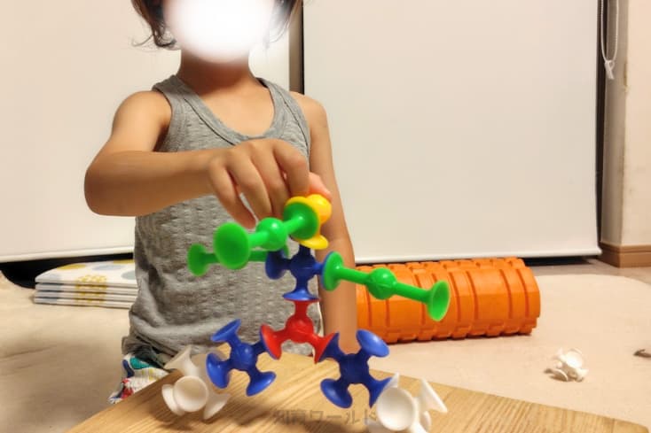 息子がピタリコをくっつけて左右対象の作品を作っているところの写真