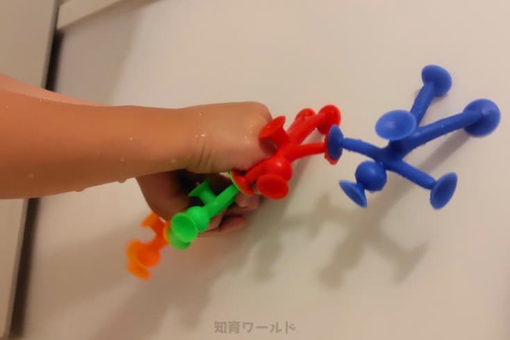 ピタリコをお風呂の壁にくっつけて遊ぶ息子の写真