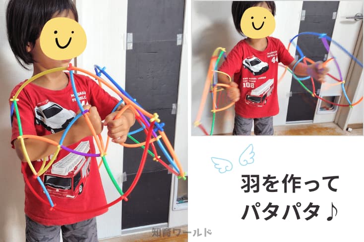 ロンビーで手にはめて使う大きな羽を作ってパタパタさせて遊んでいる5歳の息子の写真