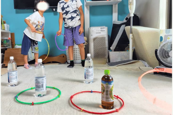 ロンビーで輪投げをして遊ぶ5歳の息子と小学生の息子の写真